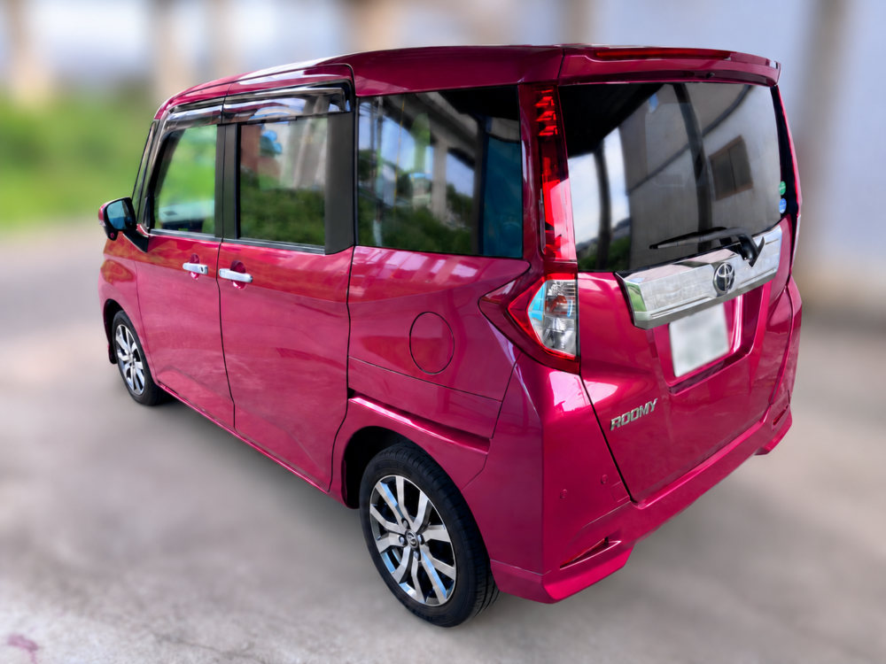 赤いトヨタ ルーミーのリアゲートとボディ側面を斜め後方から撮影した実車外観