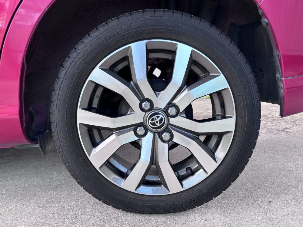 トヨタ ルーミーの左リア15インチ純正アルミホイールとタイヤを実車の正面から撮影した状態