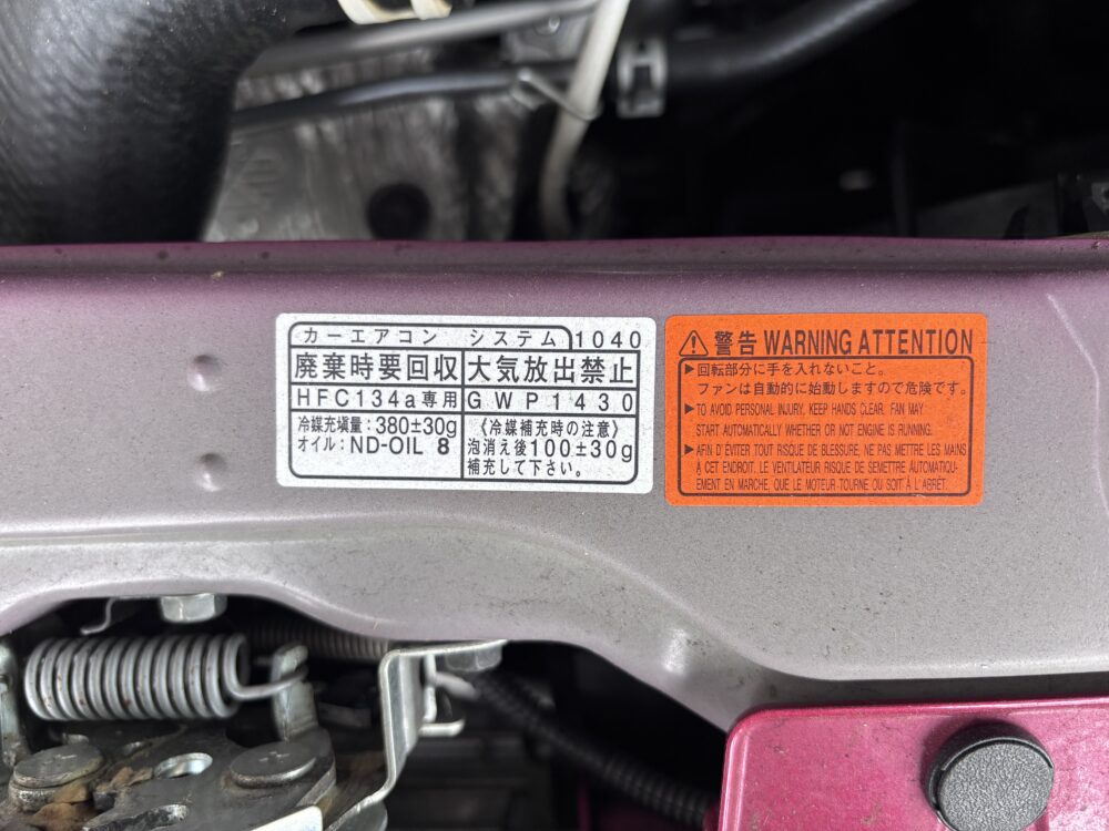 トヨタ ルーミーのエンジンルームに貼られたエアコン冷媒の種類・充填量・指定オイルの表示ラベル